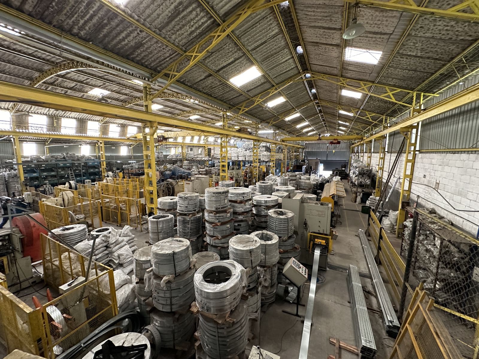Linha de produção com bobinas e máquinas na fábrica